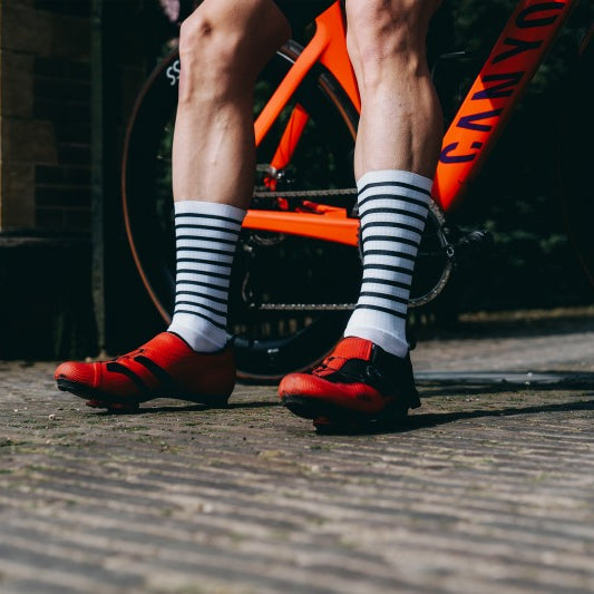 | Klassisch minimalistisch | Aerodynamische, lange Rennradsocken in Weiß und Schwarz, passend zu jedem Outfit und mit doppelter Verklebung für sicheren Halt