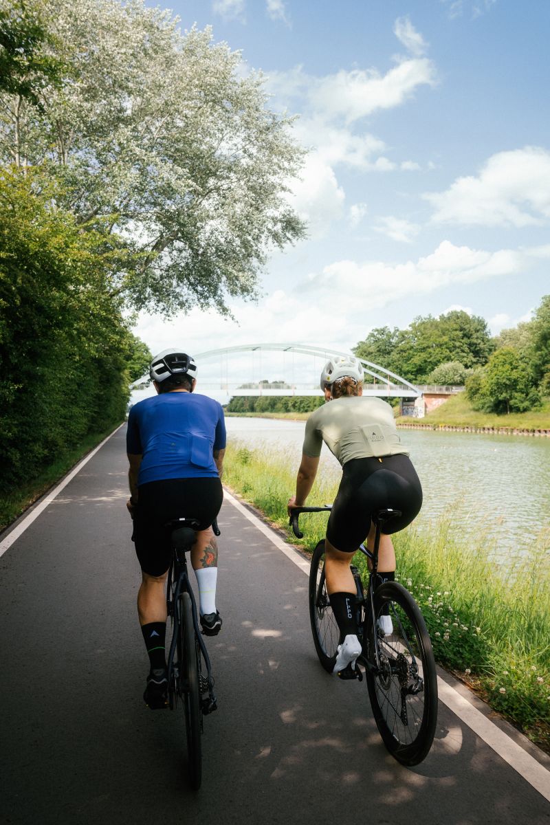 Zwei Rennradfahrer auf der Straße, von hinten aufgenommen – beide in Fahrposition