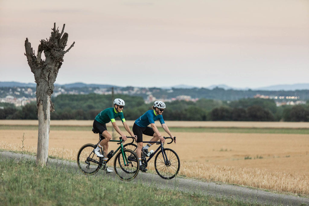 2 Rennradfahrer Mit pippo Trikot in gruen und blau mit pride Socken und schwarzer bib short