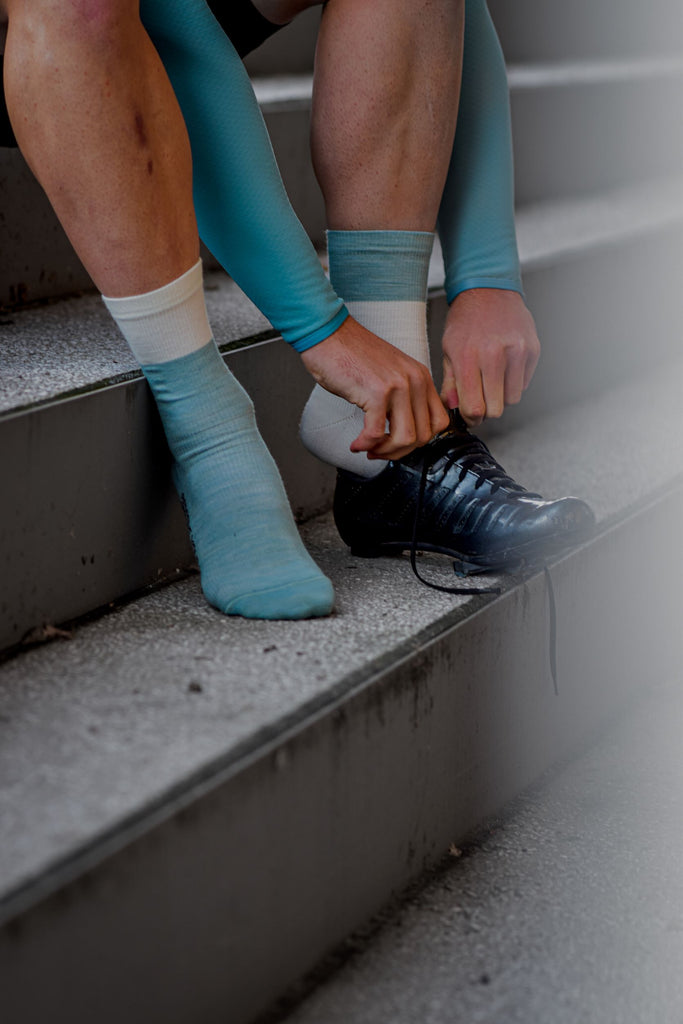 Frontansicht unserer grün-weißen Merino-Rennradsocken mit Rennradschuhen: Die perfekte Kombination aus Stil und Leistung für Ihre nächste Fahrt