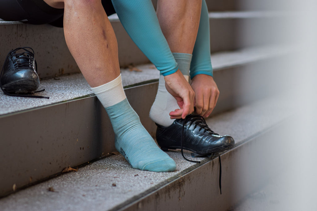 Frontansicht unserer grün-weißen Merino-Rennradsocken mit Rennradschuhen: Die perfekte Kombination aus Stil und Leistung für Ihre nächste Fahrt